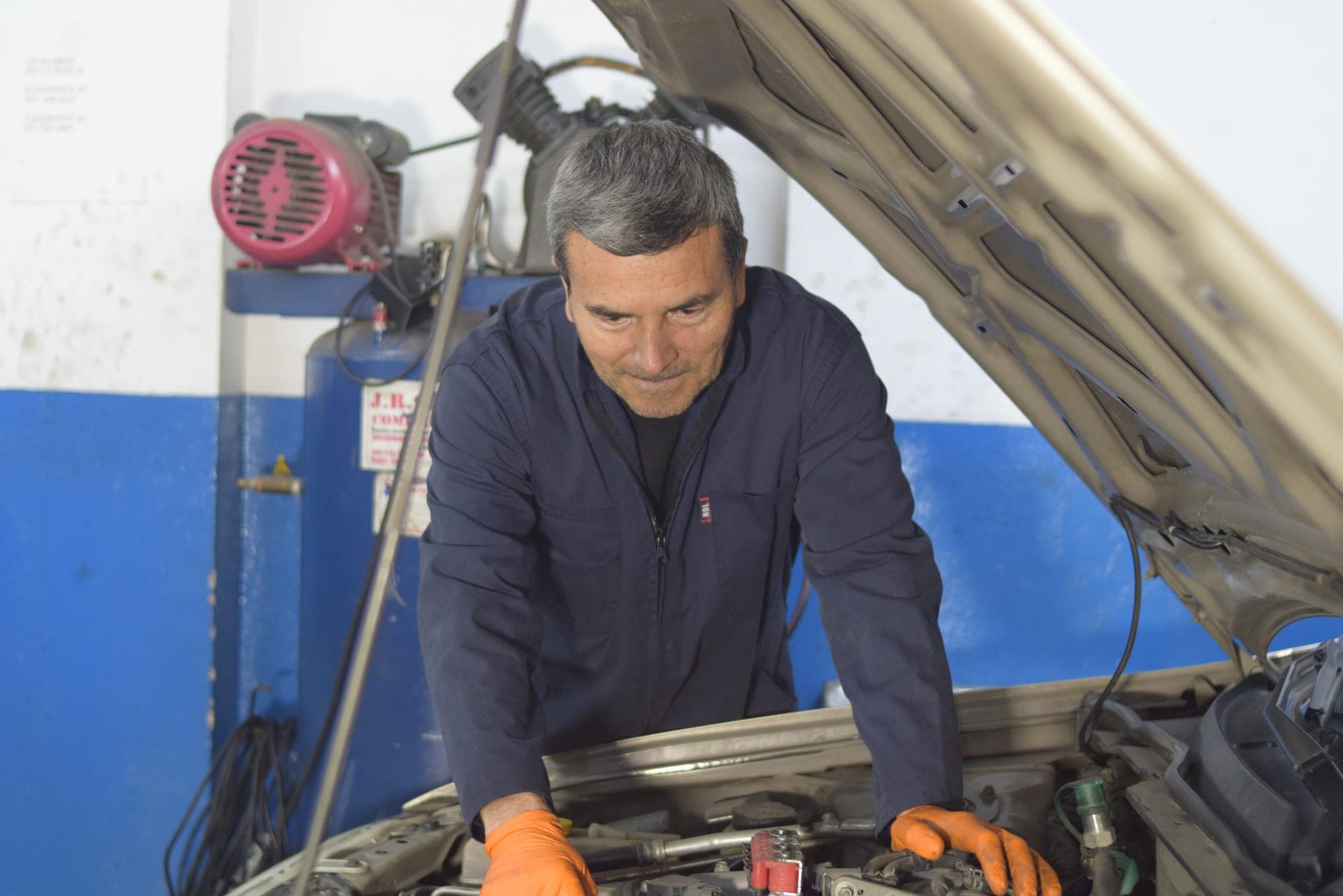 Técnico de Masmotors revisando el motor de un vehículo