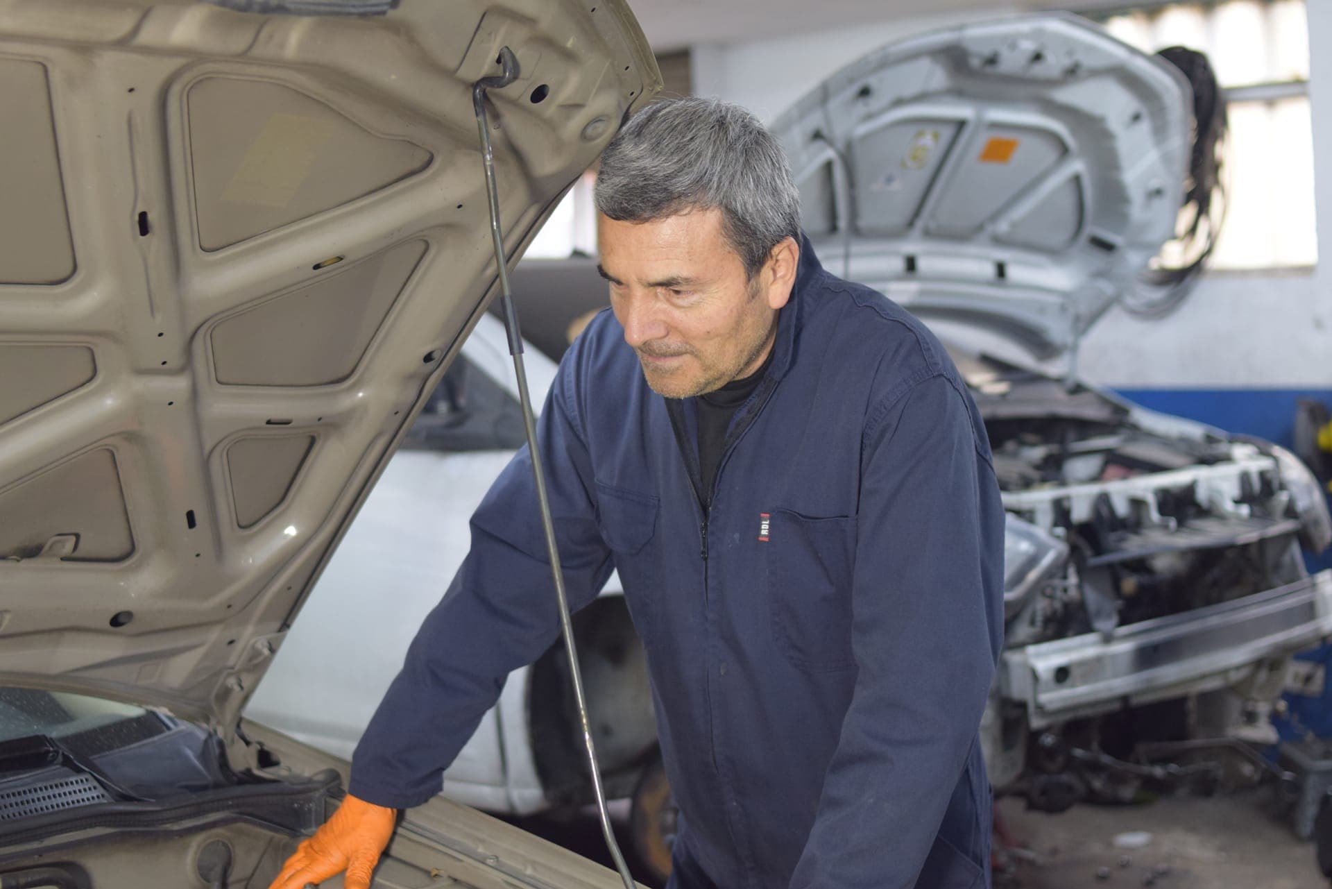 Técnico de Masmotors trabajando en el motor de un vehículo